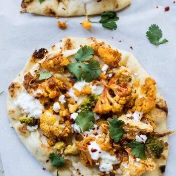 Curry-spiced roasted cauliflower on naan bread with hummus, feta and yogurt