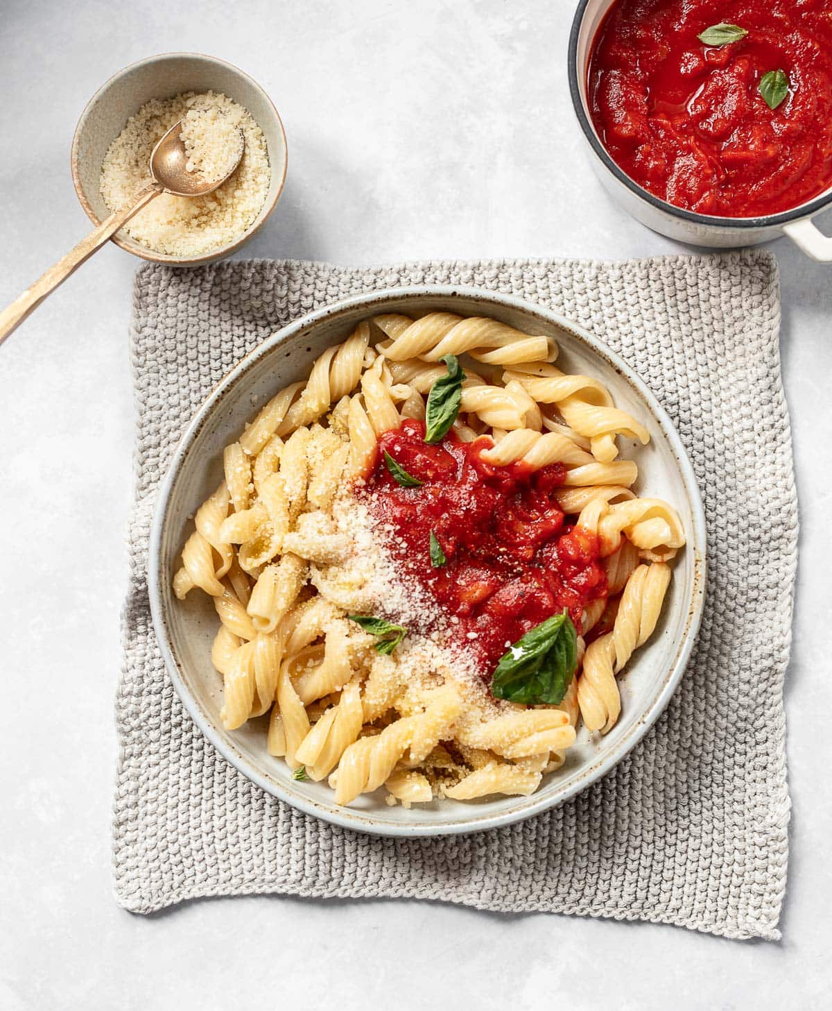 A bowl of curly pasta topped with pomodoro sauce, a recipe that includes canned tomatoes, basil and Parmesan cheese.