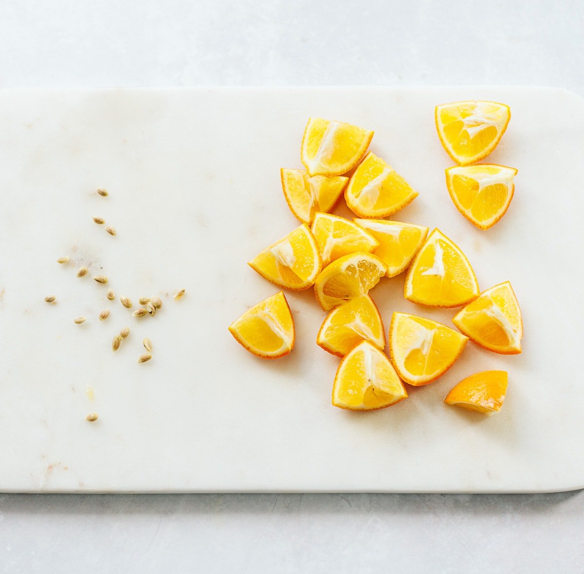 Wedges of Meyer lemon on a marble board, with seeds removed.