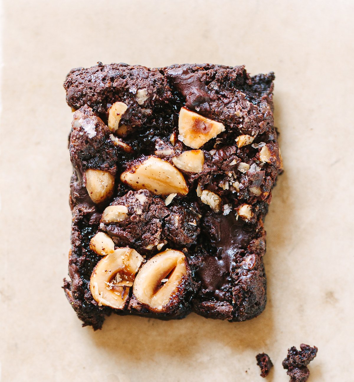 A close up picture of a a chocolate hazelnut brownie square, with gooey melted chocolate on top.