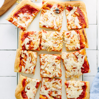 Rectangular slices of cheese pizza on a cutting board.