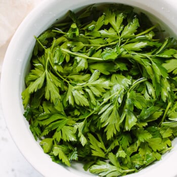 Flat leaf parsley soaking in a bowl of water.