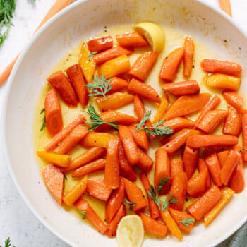 Glazed carrot pieces in a skillet.