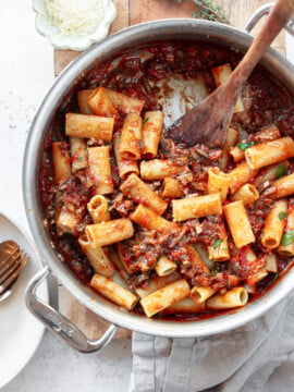 Rigatoni pasta and mushroom sauce in a skillet, with a spatula..