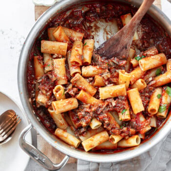 Rigatoni pasta and mushroom sauce in a skillet, with a spatula..