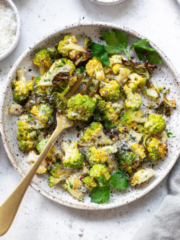 Roasted romanesco cauliflower and a fork on a serving plate.