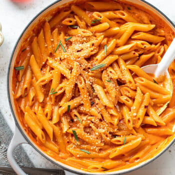 Penne pasta with creamy tomato-vodka gin sauce in a white skillet.