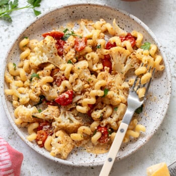 Gemelli pasta with roasted cauliflower sauce on a serving plate, with a fork on the side.