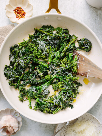 Sauteed broccoli rabe in a skillet with olive oil and garlic.
