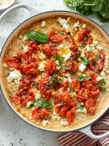 Roasted tomatoes, basil and goat cheese atop a skillet of baked polenta.