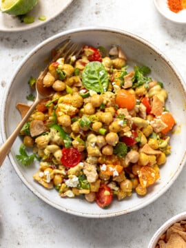Chickpea salad mixed with sliced tomatoes, cilantro and feta cheese in a serving bowl.